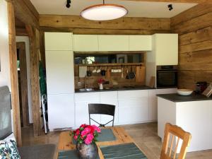 a kitchen with white cabinets and a table at Apartment Stillleben Luxus für die Seele in Abtenau