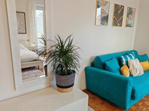 un sofá azul en una sala de estar con una maceta en Verdeacquassisi, en Rivotorto