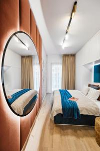 1 Schlafzimmer mit einem Spiegel und 2 Betten in der Unterkunft Golden Dreams Luxury Apartments 21 in Krakau