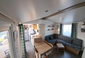 davorel mobil home في لو ماثيز: غرفة معيشة مع أريكة وطاولة في كرفان