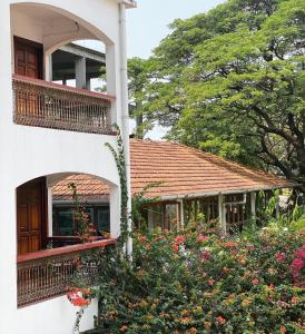 a white building with a balcony and flowers at The Killians Boutique Hotel in Cochin