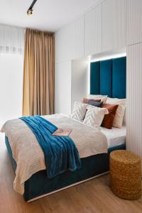 ein Schlafzimmer mit einem großen Bett mit blauem Kopfteil in der Unterkunft Golden Dreams Luxury Apartments 21 in Krakau