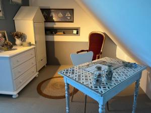 CherrueixにあるVilla Noroitのテーブル、椅子、ドレッサーが備わる客室です。