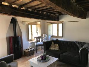uma sala de estar com um sofá preto e um fogão a lenha em Casa Al Fondo em Gualdo di Macerata