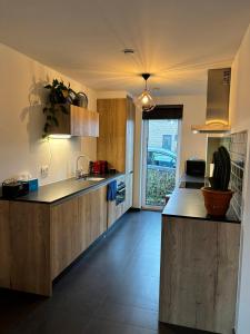 uma cozinha com armários de madeira e uma bancada em Maison Seigneur em Asse