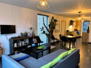 a living room with a blue couch and a table at Maison Seigneur in Asse