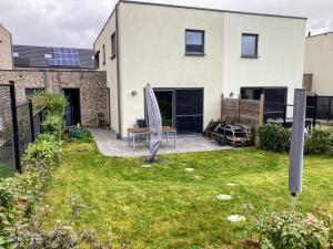 un patio con sombrilla y una casa en Maison Seigneur, en Asse