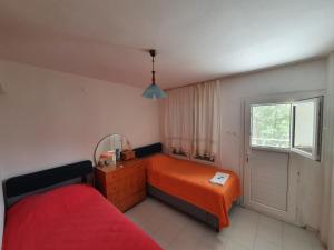 Schlafzimmer mit einem Bett, einem Spiegel und einem Fenster in der Unterkunft Bahçeli çift katlı villa sahile 300 metre in Kusadası