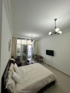 a bedroom with a bed and a flat screen tv at Cozy Private Studio APT in Al Mamzar Sharjah in Sharjah