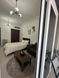 a bedroom with a bed and a couch and a table at Cozy Private Studio APT in Al Mamzar Sharjah in Sharjah