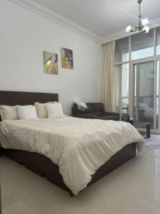 a bedroom with a large bed and a chair at Cozy Private Studio APT in Al Mamzar Sharjah in Sharjah