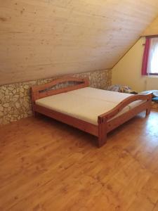 ein Schlafzimmer mit einem Holzbett im Dachgeschoss in der Unterkunft Chata Naděje in Raspenava