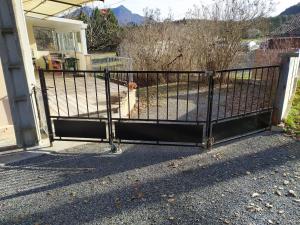 an iron gate in front of a house at les mésanges in Chaffaut-Lagremuse