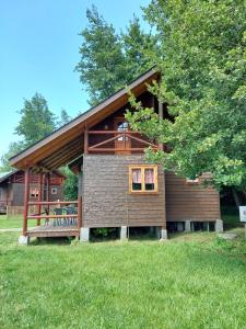 a large wooden house with a porch and a tree at Cabanas Turismo Don Ambrosio in Salto del Laja