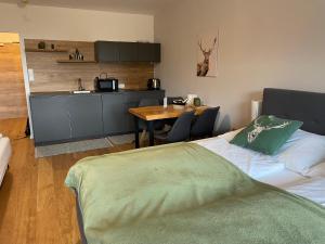um quarto com uma cama e uma cozinha com uma mesa em Wolfgangsee Ferienappartement „Almliebe“ em Strobl