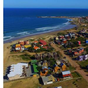 a group of houses on a beach next to the ocean at El Tucán 1 in Punta Del Diablo