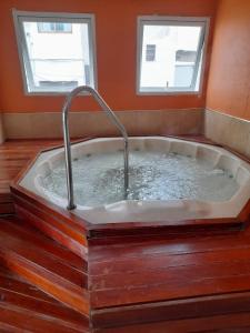 a bath tub with a faucet and two windows at Hotel Monterrey in Termas de Río Hondo