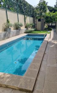 a swimming pool with blue water in a yard at Still Waters - A Cottage by the Lake! in Boralesgamuwa