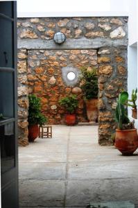 a stone wall with potted plants and a window at Dar Dielna in Oualidia