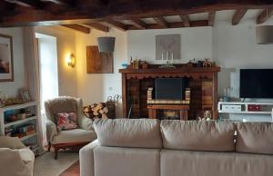 a living room with a couch and a fireplace at La Tour du Boueix in Préveranges +15 photos