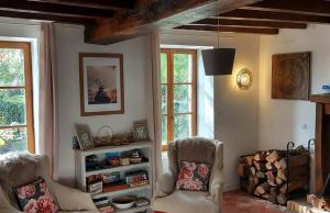 ein Wohnzimmer mit 2 Stühlen und einem Bücherregal in der Unterkunft La Tour du Boueix in Préveranges