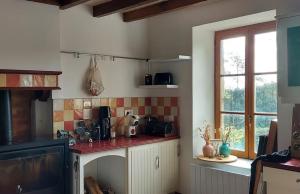 eine Küche mit einer Arbeitsplatte und einem Fenster in der Unterkunft La Tour du Boueix in Préveranges