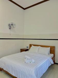 a bedroom with a white bed with a fan at BeachSide House Mui Ne II in Ấp Khánh Phước (1)