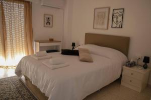 1 dormitorio con 1 cama blanca y 2 toallas en Cozy 2 Bdr Nicosia City Free Parking Wifi, en Nicosia