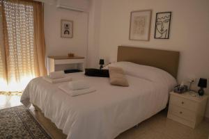 a bedroom with a white bed with two towels on it at Cozy 2 Bdr Nicosia City Free Parking Wifi in Nicosia