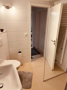 La salle de bains est pourvue de toilettes, d'un lavabo et d'un miroir. dans l'établissement Appartment Schmidtner, à Ansbach
