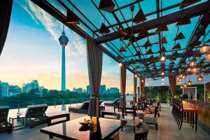 a restaurant with tables and chairs and a view of the city at Hotel Stripes Kuala Lumpur, Autograph Collection in Kuala Lumpur
