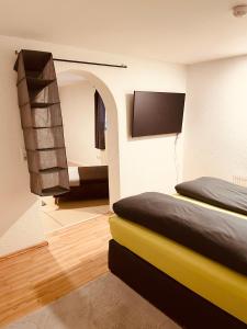 a bedroom with two beds and a tv on the wall at Appartment Schmidtner in Ansbach