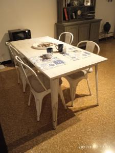 a white table with four chairs around it at Acquario Inn Genova House in Genoa