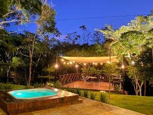 een achtertuin met een zwembad in de nacht bij Chalé Novo - 4 quartos - 12 camas - Hidromassagem e Ar condicionado nos quartos - Cond Montserrat in Guaramiranga