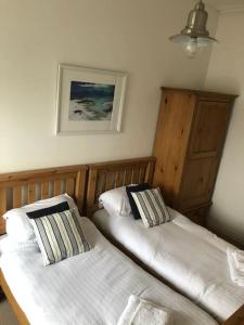 a bedroom with two beds and a picture on the wall at Millport Beach Apartment, Crichton St, sea views in Millport