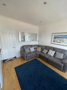 a living room with a couch and a blue rug at Millport Beach Apartment, Crichton St, sea views in Millport