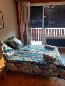 a bedroom with a bed with a blue comforter at Studio cabine au cœur de la montagne Les Memises in Thollon