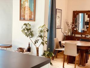 a living room with a dining room table and a plant at Georgian Guest Rooms in Basel