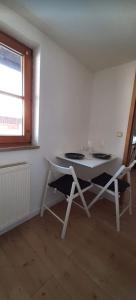 a white table and chairs in a room with a window at Ferienwohnung in Nesselwang, Allgäu Bergfreunde in Nesselwang