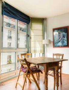 - une salle à manger avec une table et des chaises en bois dans l'établissement Charmant 3P. Calme, spacieux et lumineux. 90 m2, à Paris