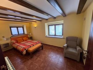 1 dormitorio con 1 cama y 1 silla en Casa rural María Juliana en Talayuelas