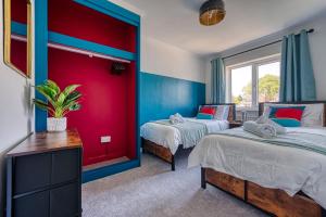 Duas camas num quarto com paredes vermelhas e azuis em Large 4 bedroom house - driveway - close to NEC! em Solihull
