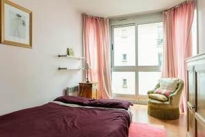 ein Schlafzimmer mit einem Bett, einem Stuhl und einem Fenster in der Unterkunft Charmant 3P. Calme, spacieux et lumineux. 90 m2 in Paris