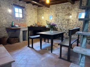a dining room with a table and chairs and a stone wall at Tuscany Escape in Borgo a Mozzano