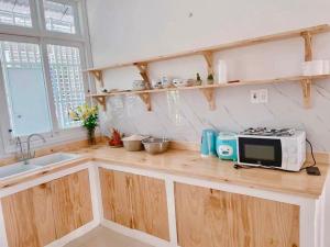 a kitchen with a counter with a microwave and a sink at LaLa Villa Hue in Hue
