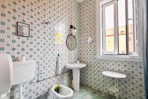 a bathroom with a toilet and a sink and a window at Ambiente Hostel in Lisbon +40 photos