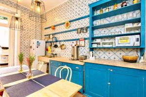 a blue kitchen with a table and blue cabinets at Ambiente Hostel in Lisbon