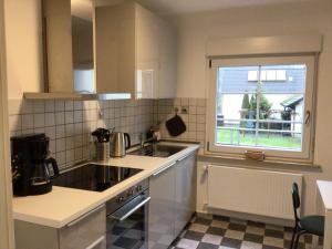 a small kitchen with a sink and a window at Ferienwohnung am Steinsbach in Bad Berleburg