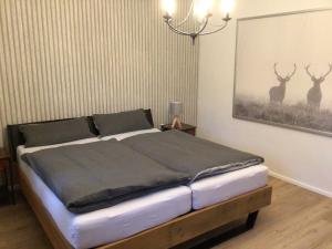 a bedroom with a bed with deer paintings on the wall at Ferienwohnung am Steinsbach in Bad Berleburg