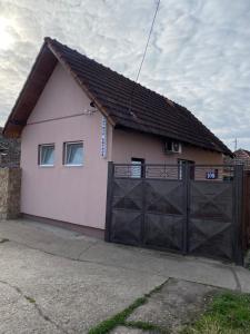 a pink house with a black garage door at Apartman Arthur in Kikinda
